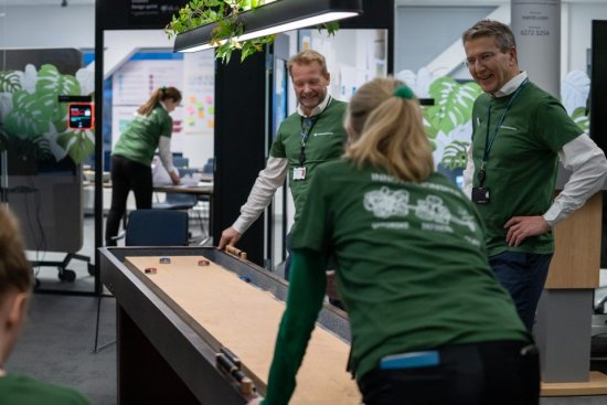Gruppe mennesker som spiller shuffleboard på kontoret