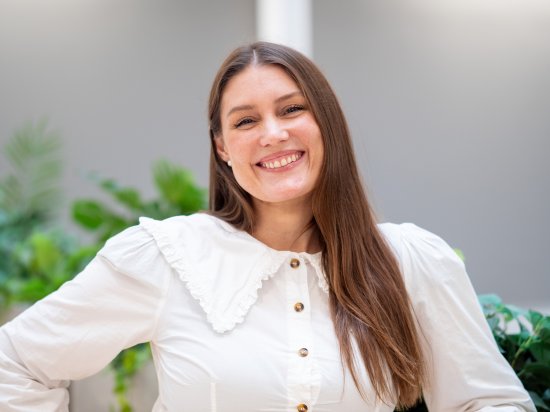 Portrettbilde av smilende dame med langt mørkt hår